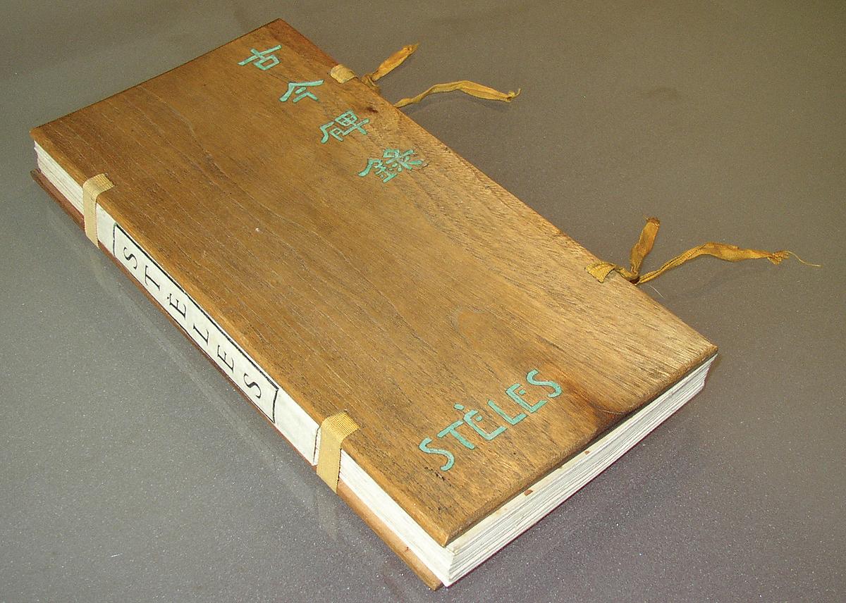 Wood bound book, held together with leather thongs