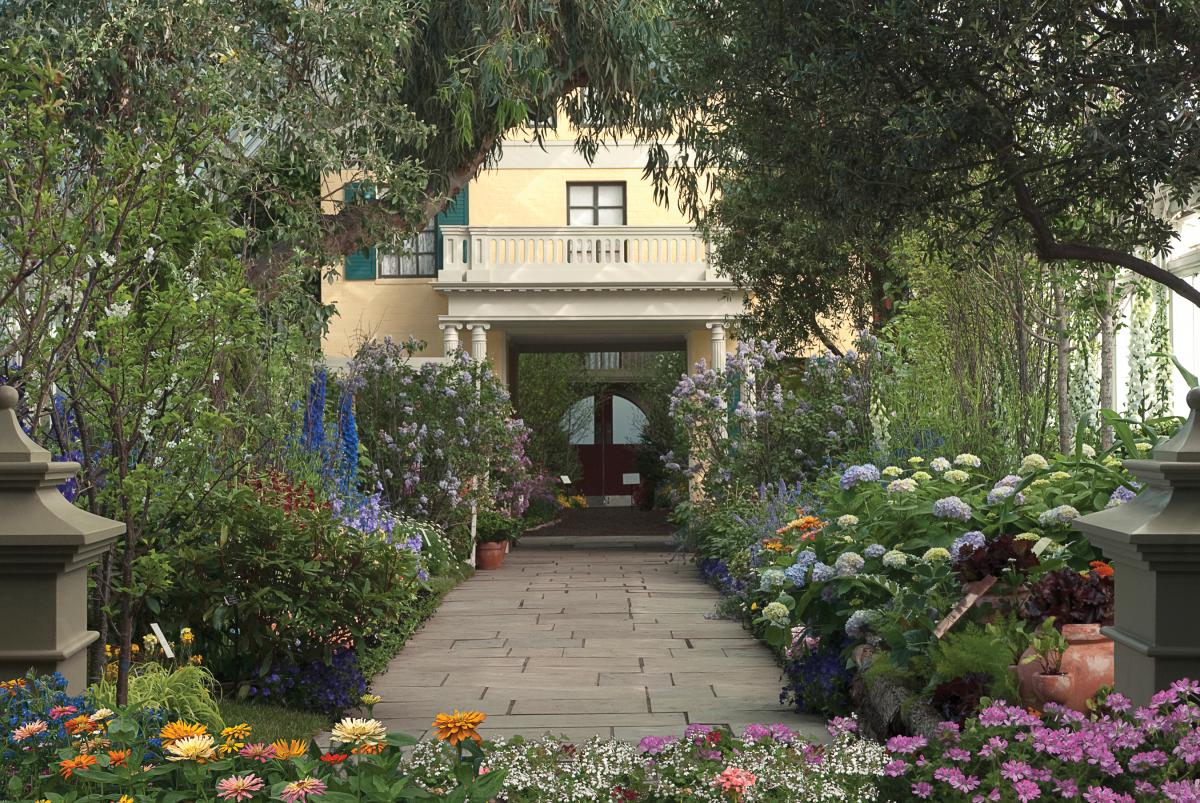 Photograph of a stone path surrounding by flowers leading up to the door of a house
