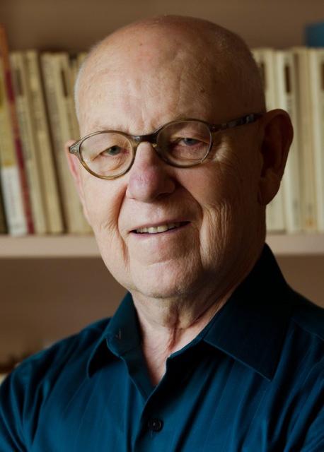 Head shot of Wilken, wearing glasses and a teal collared shirt