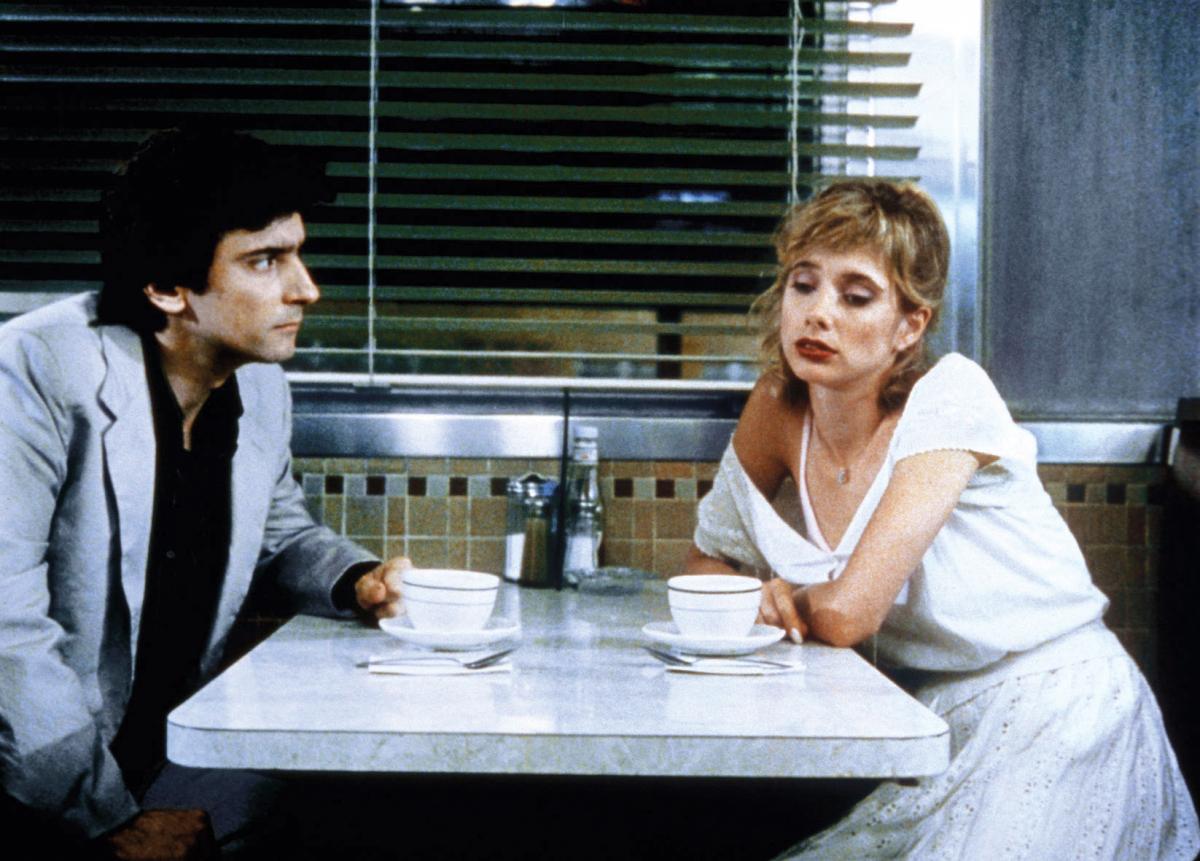 Arquette looks away from Dunne, as the two sit in a white diner booth