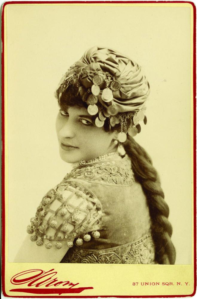 Portrait of woman with long braid looking over her shoulder