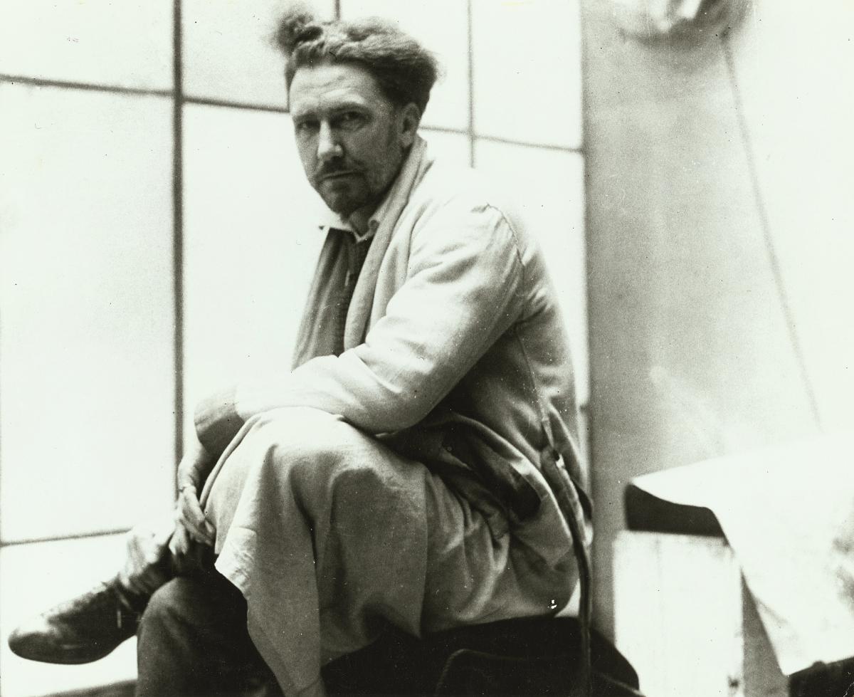 black and white photo of one of Ezra Pound, sitting with his legs crossed