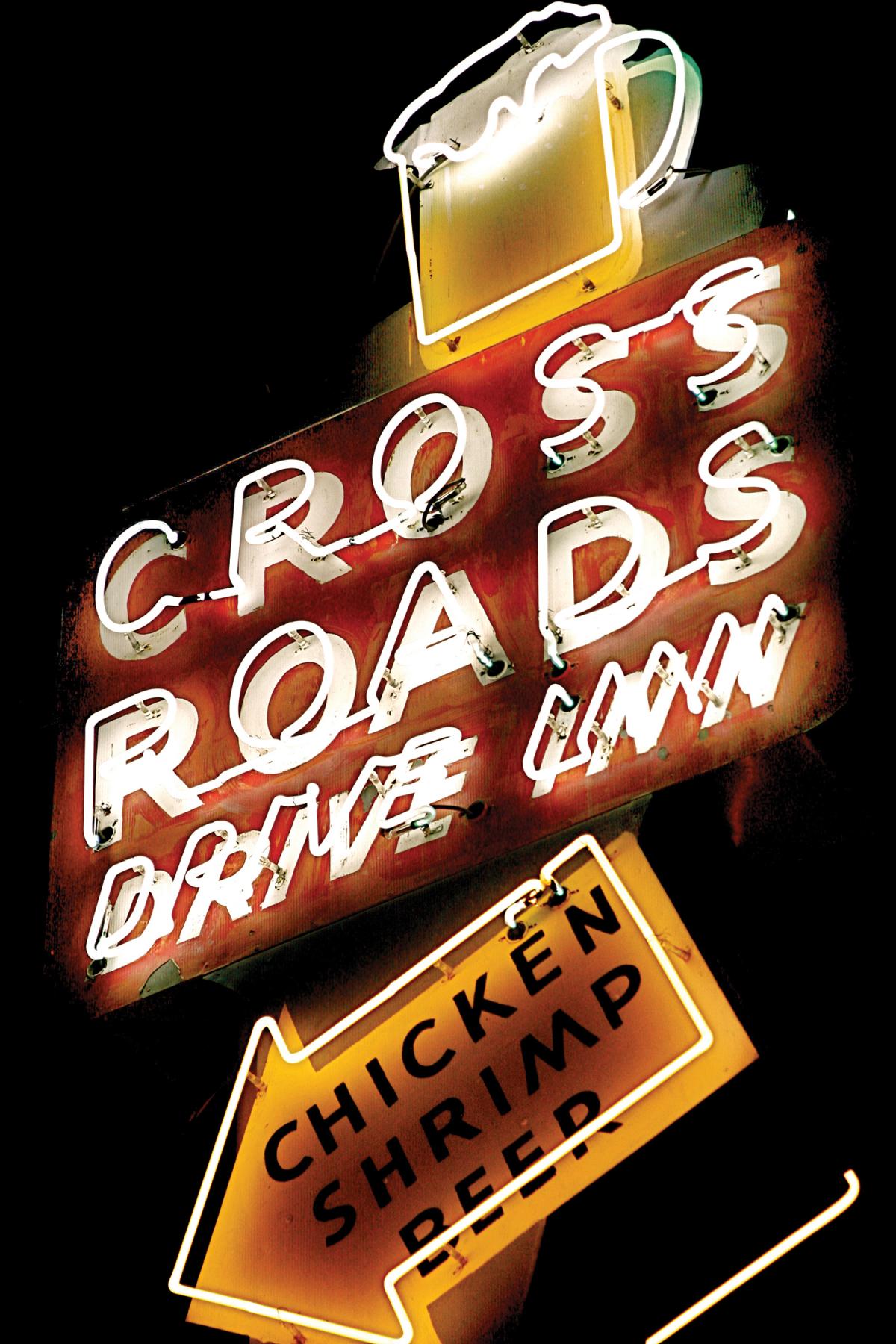 Neon sign reading "Cross Roads Drive Inn"