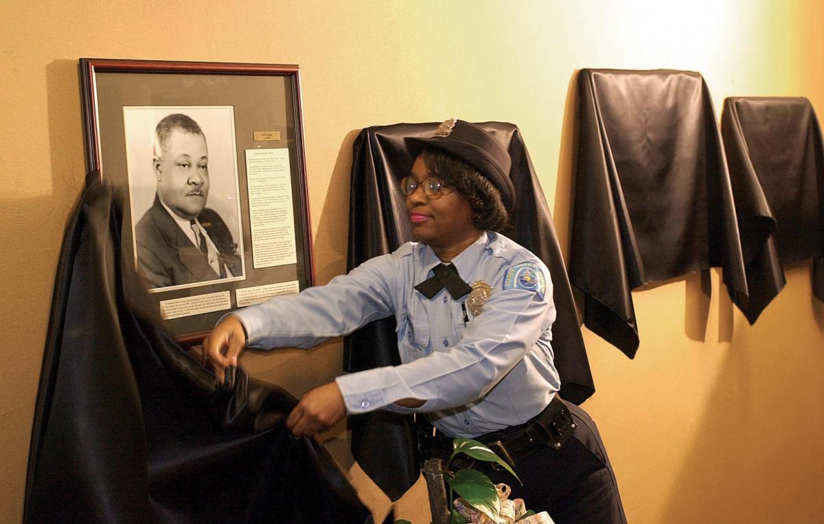 Police Joanne Glover unveils a portrait of Ira Cooper at the St. Louis Police Academy in 2001.