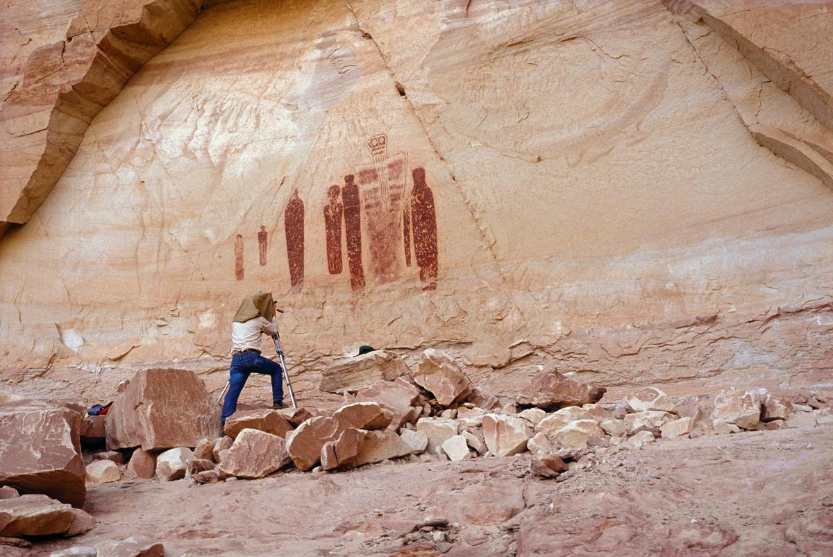 photograph of a man looking at a cave painting