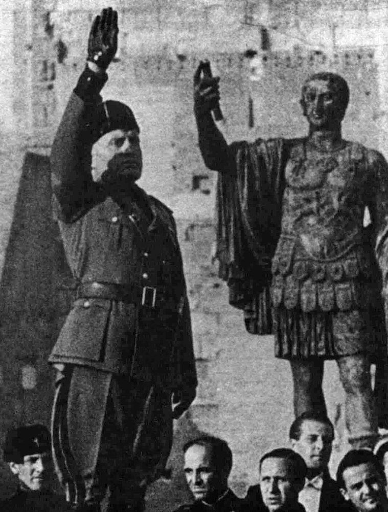 Mussolini saluting with statue of Emperor Augustus in the background