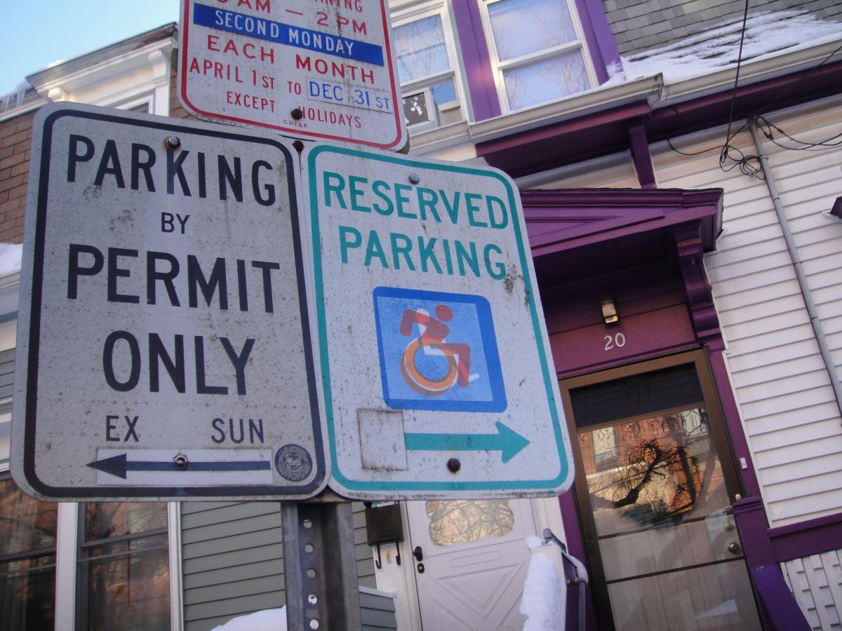 A street sign showing a wheelchair user leaning forward. 