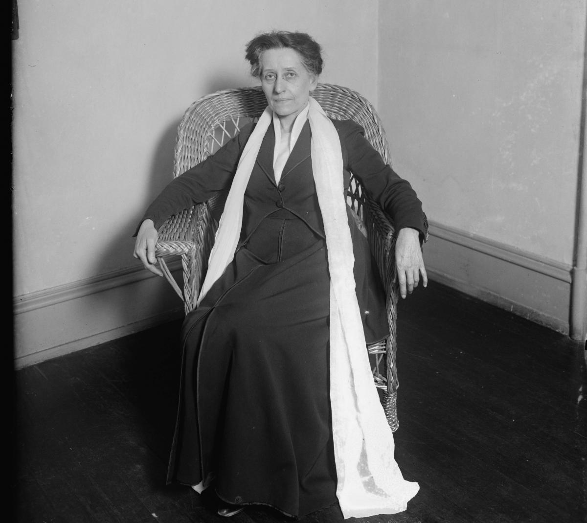 Adelaide Johnson, looking every bit the mature artist, seated in a wicker chair and draped in a long white scarf