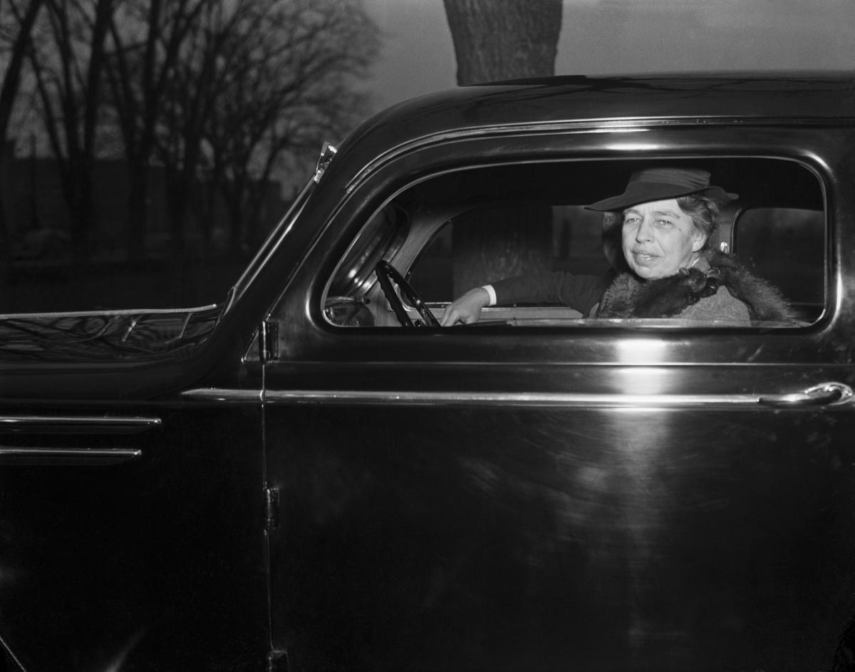 Black and white photograph of Eleanor Roosevelt driving a black car