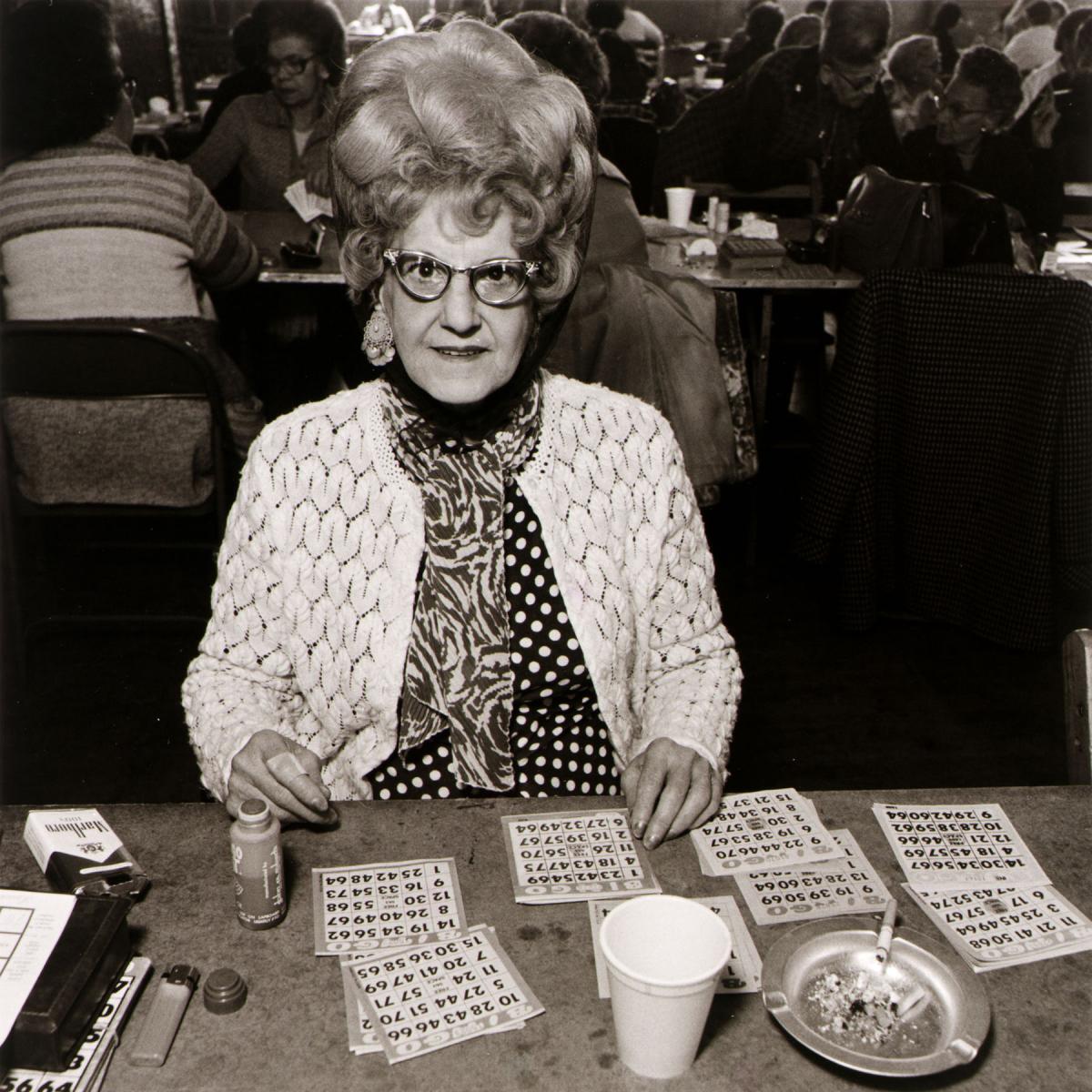 black and white photo of woman with big beehive playing bingo