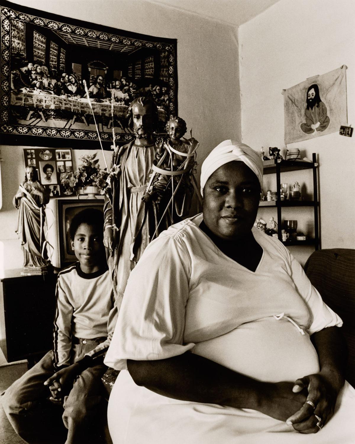 black and white photo of a Black woman and son in their home.
