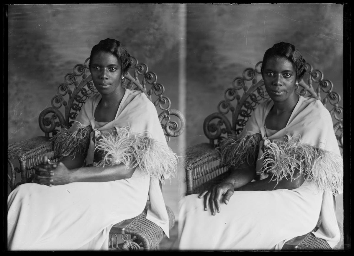 portrait of Black woman sitting on a rattan chair