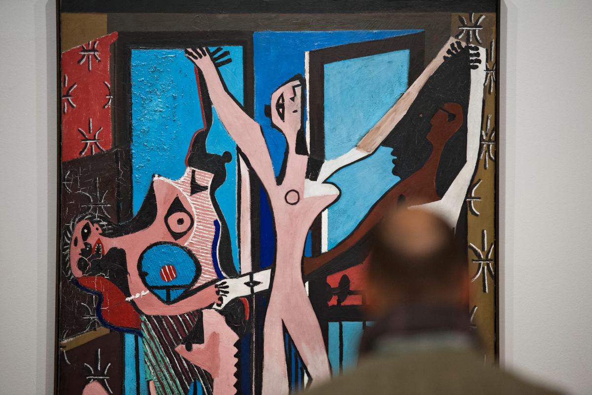 Photo of a man looking at Picasso's painting Three Dancers