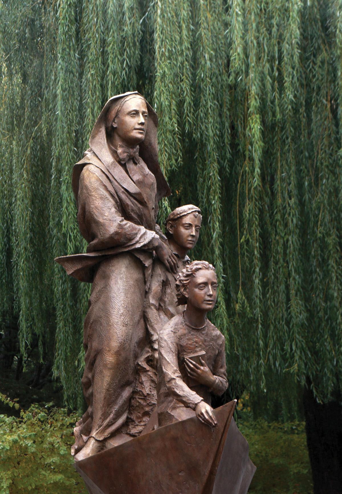 Bronze statue of Cabrini next to two children