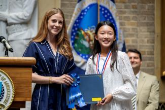 student Jiyun receiving American Heroes Student Art Contest award