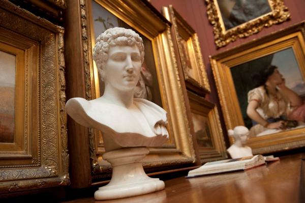 bust in front of picture frames