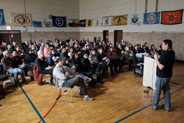 People sitting down in a gym at a common heritage event