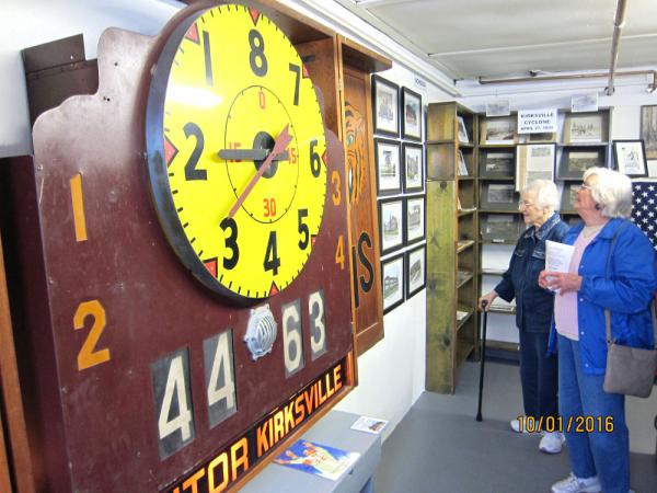 Two women viewing a vintage scoreboard