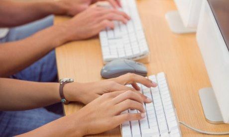 Photo of two people typing on keyboards