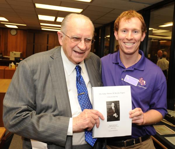 Two men holding a paper