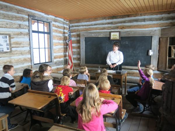 Children and teacher in a schoolhouse