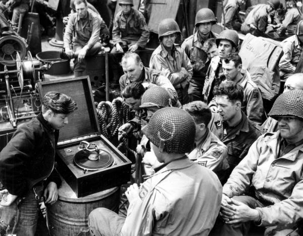 Soldiers listen to music on their way from England to Normandy, 1944