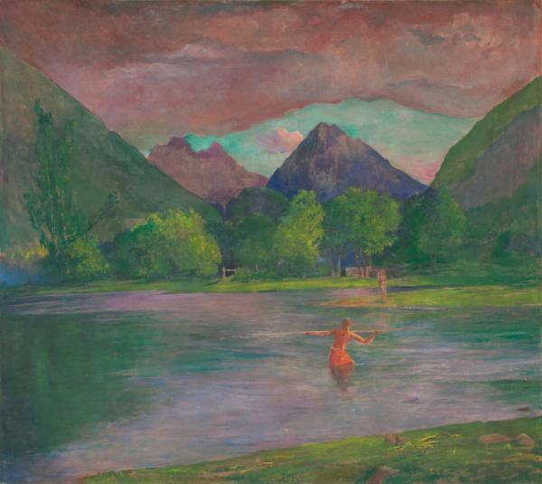 A native fisherman in the river, with mountains in the distance.