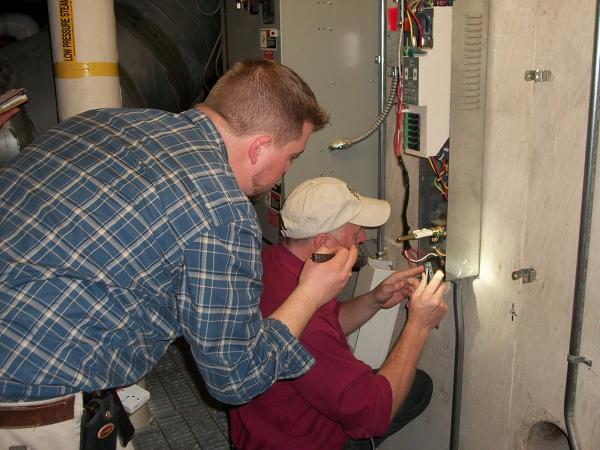 Preservation Environment consultant and HVAC mechanic take a monitor reading. 