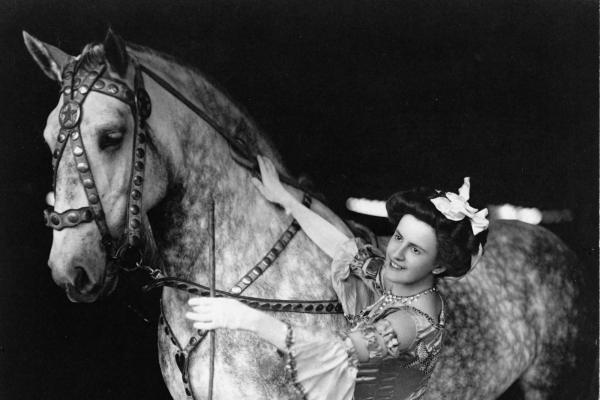 Female bareback rider in costume with horse.