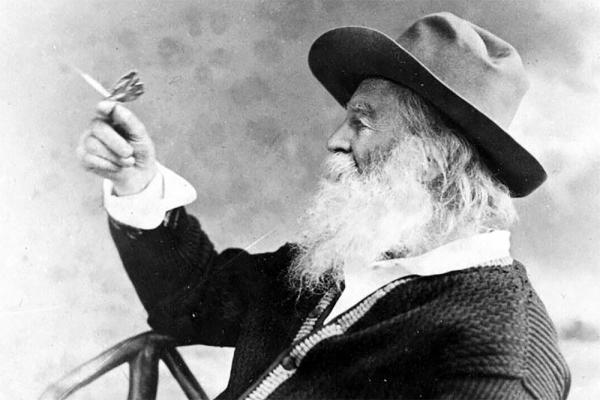 American poet Walt Whitman holding a butterfly.