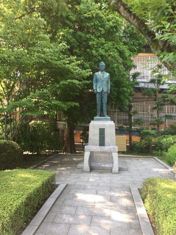 A statue of a man standing in a garden in Japan.
