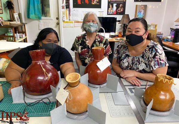 Conservator Linda Hee trains the team on housing for fragile feathered gourds called ʻulīʻulī.