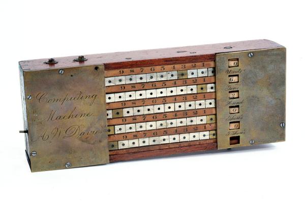 Photograph of a Davies Adding Machine, a rectangular metal contraption with five continuous metal bands that move in slots across a wooden frame.