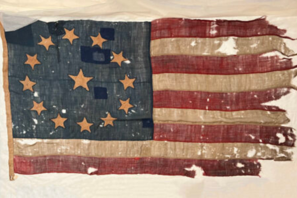 Colonial era American flag with 13 stars, 9 stripes and holes in the flag