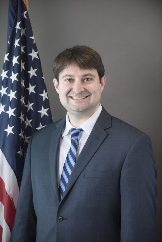 Photo of William English in front an American flag