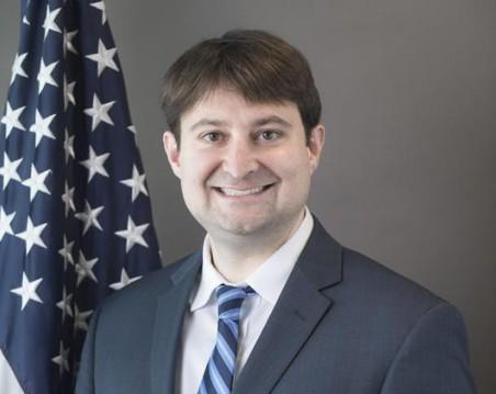 headshot of Bill English next to American flag 