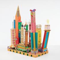 Photograph of a cityscape constructed by Bodys Isek Kingelez with approximately a dozen brightly-colored buildings.