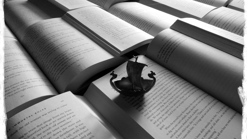 Small model boat resting on top of an open book