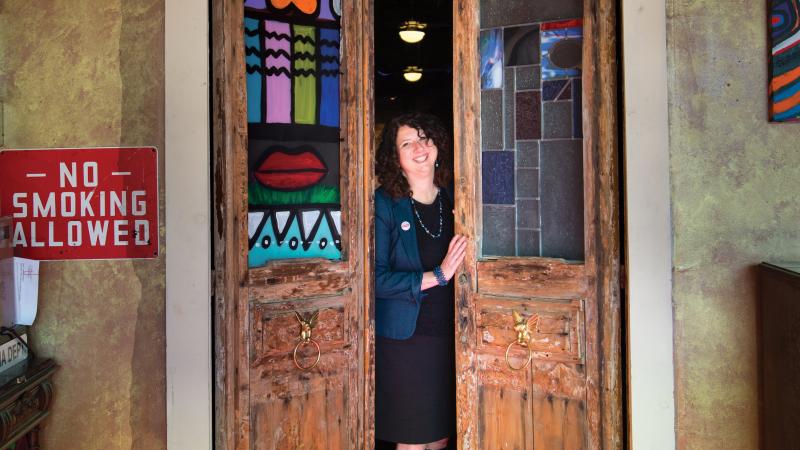 Photograph of woman in between two doors that are ajar