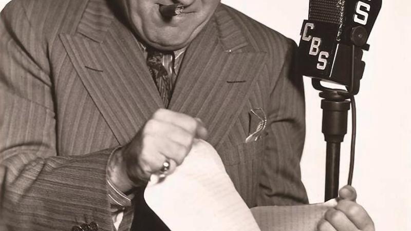 Black and white photo of Harry Conn before a microphone