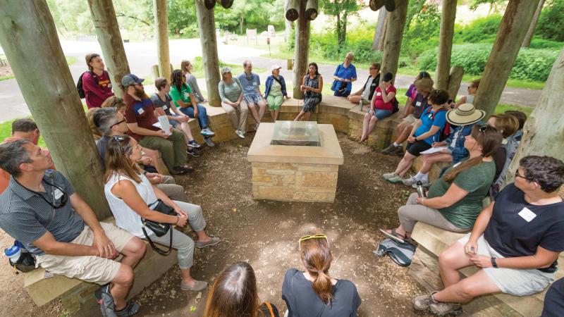 Visitors listen to a guide during a tour of the bdote sites