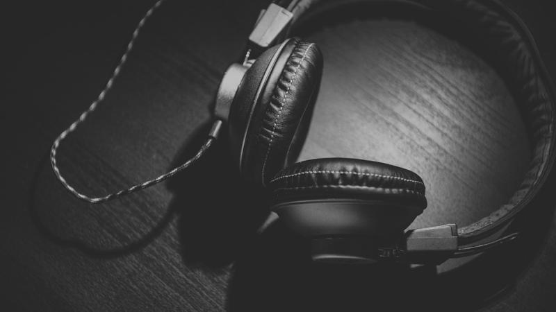 Black headphones lying on a black tabletop