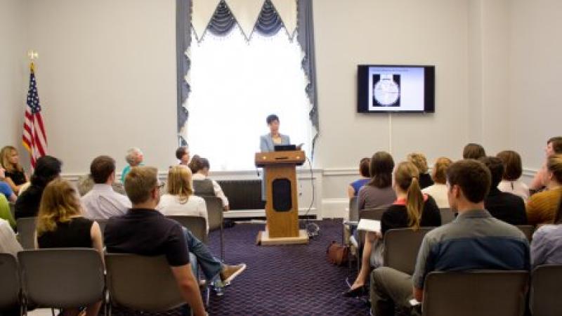 A woman in a suit giving a presentation before an audience