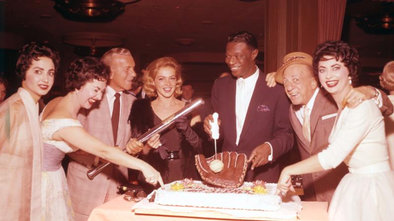photo of people gathered around a birthday cake