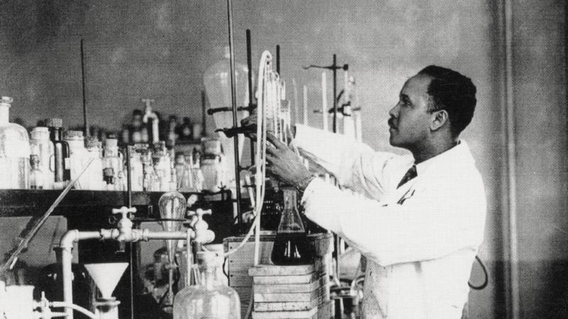 black and white photo of a man working with lab equipment