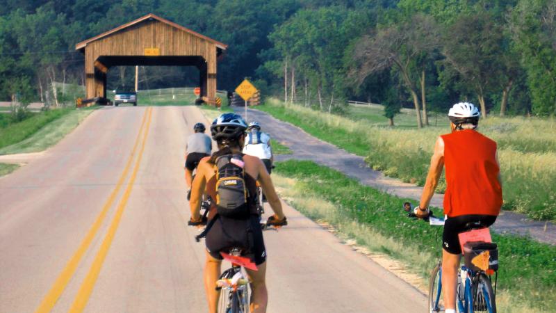 Photograph of two people on bikes on a road