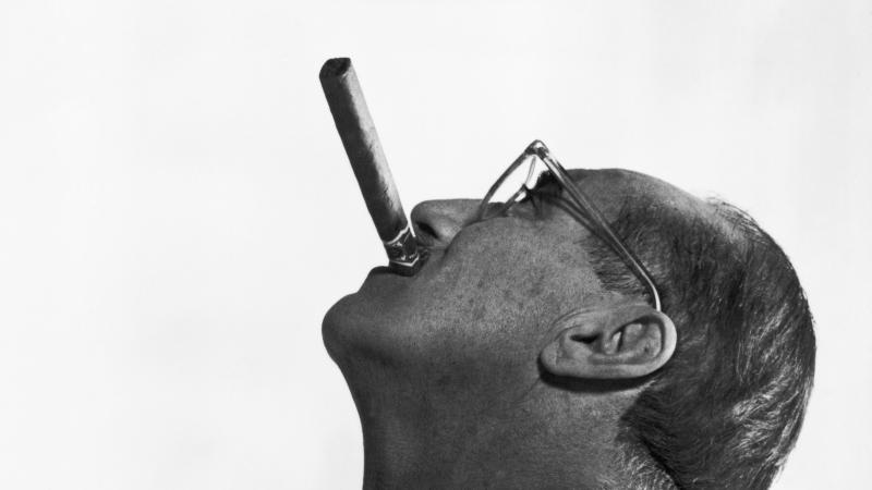 Side view of Groucho Marx, face tilted to the sky, smoking a cigar