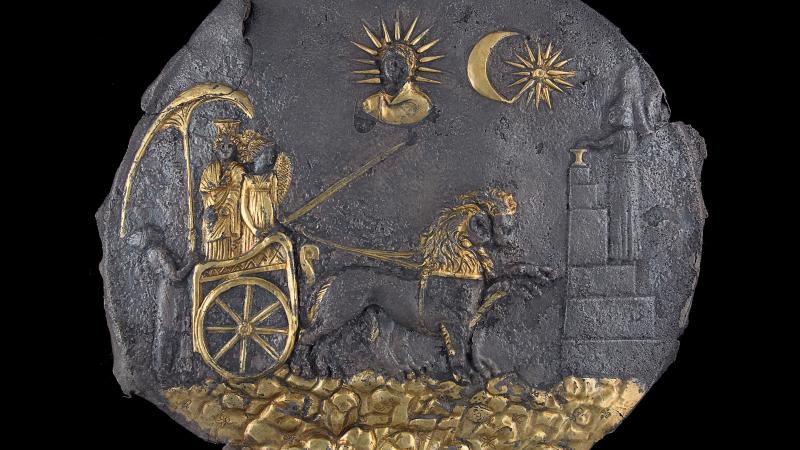 ancient plaque with gold embellishments, two figures in chariot