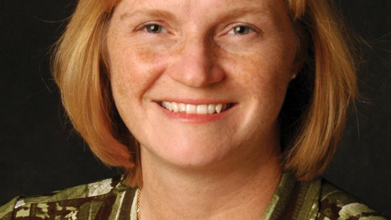 Rippy, auburn hair cut to her shoulders, in a green and brown striped blouse