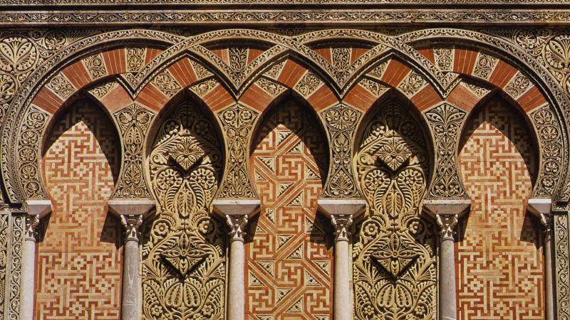 Inerlacing arches decorated with intricate floral and geometric patterns in red and gold